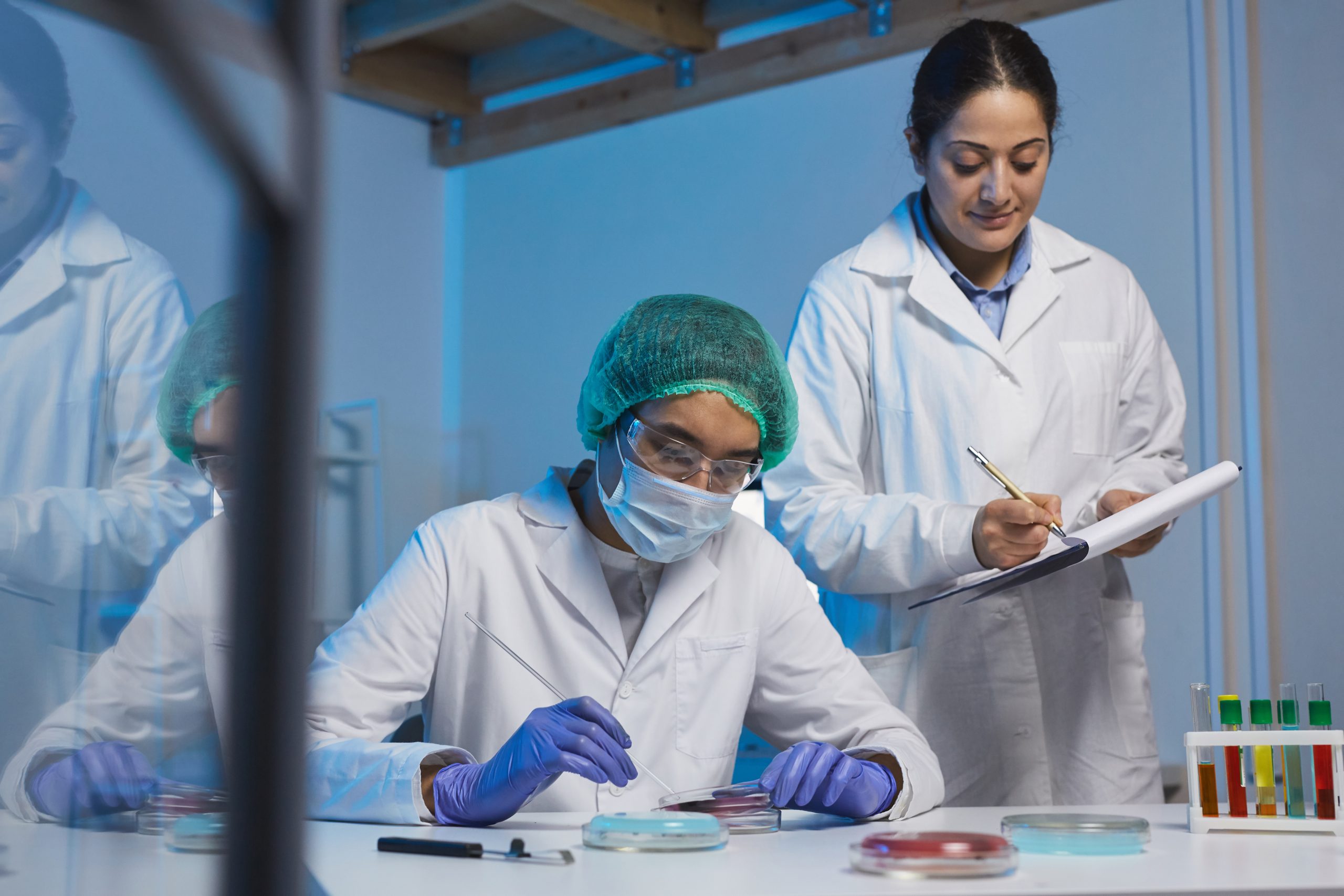 Indian assistant making notes about changes of microorganism