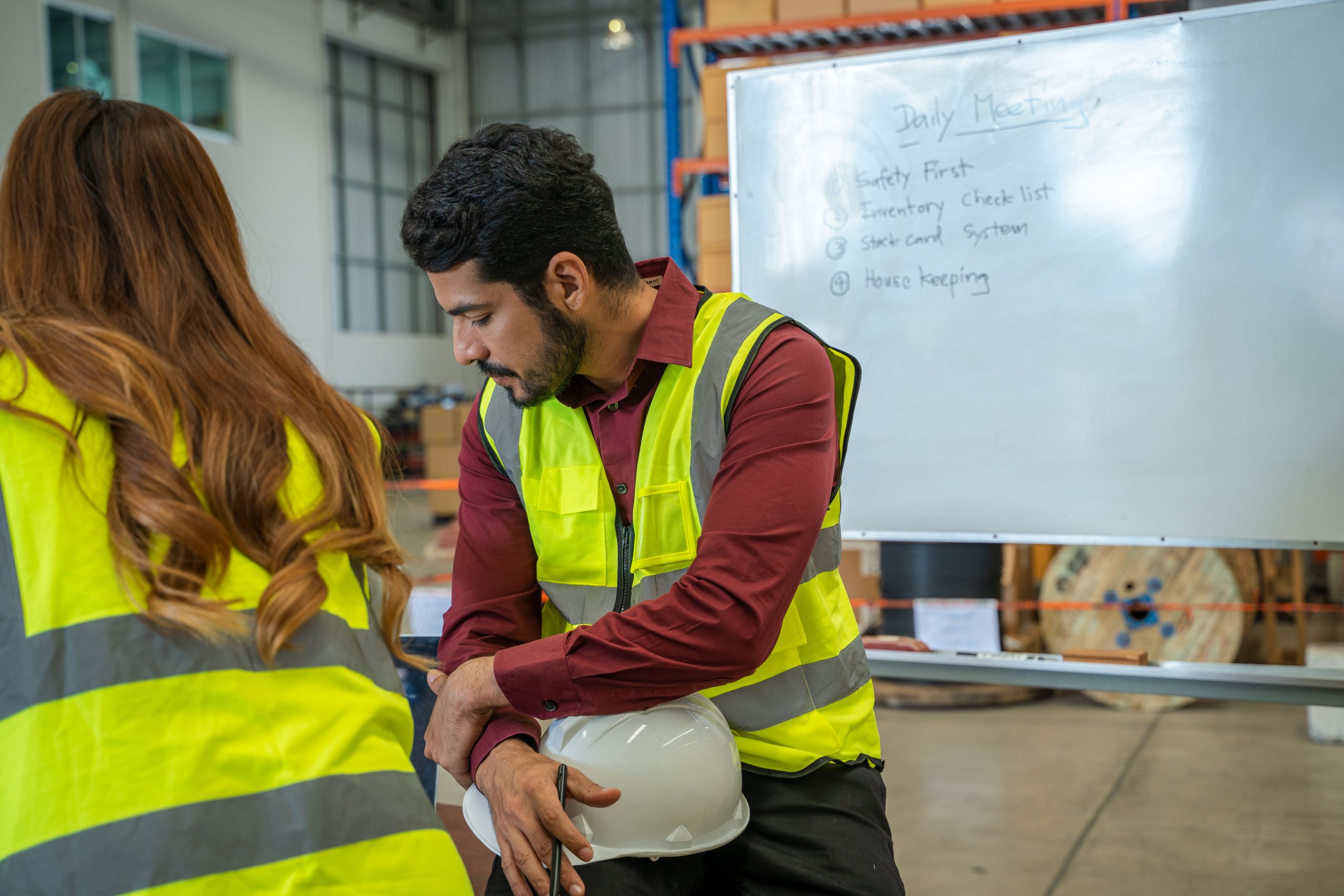Group of warehouse workers have a briefing in a large distributi
