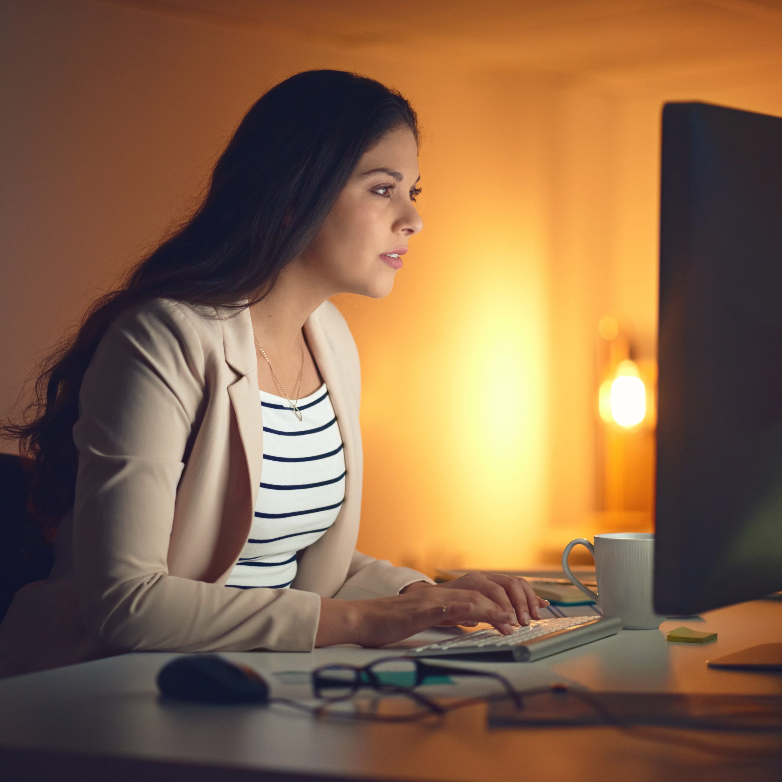 Shot of a young businesswoman using a computer during a late night at work.