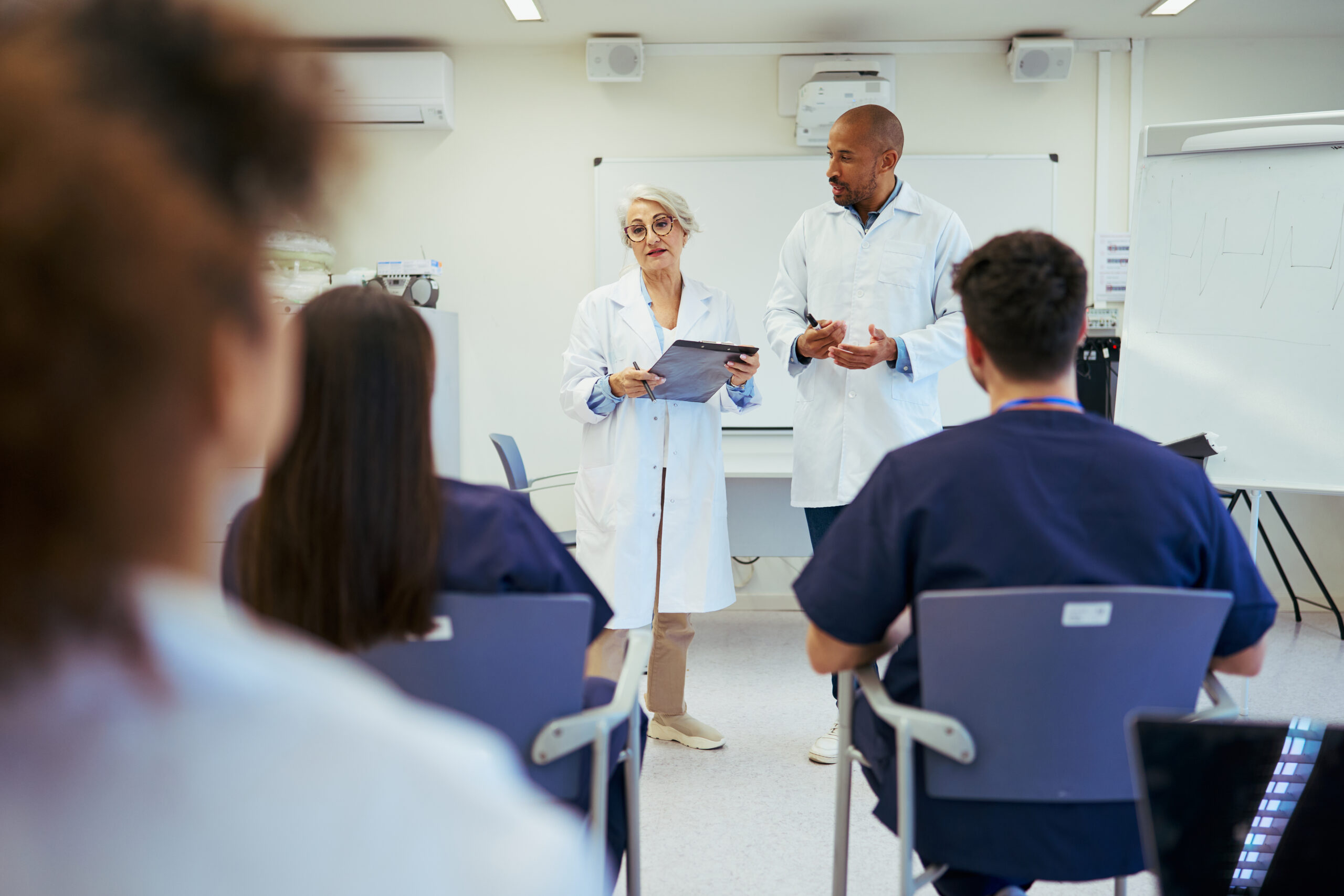 Doctors giving a lecture to medical students in modern hospital classroom