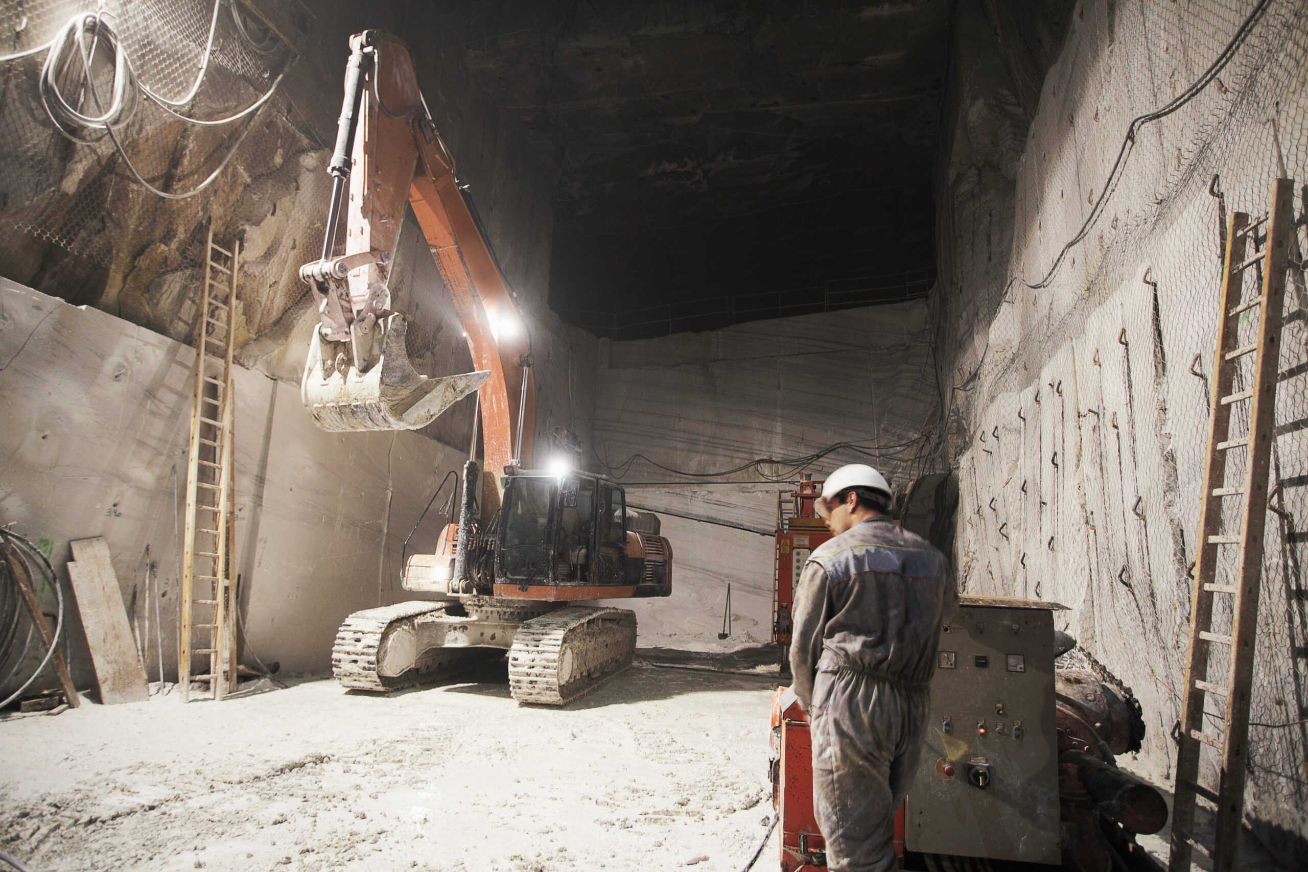 Worker and excavator in a marble quarry