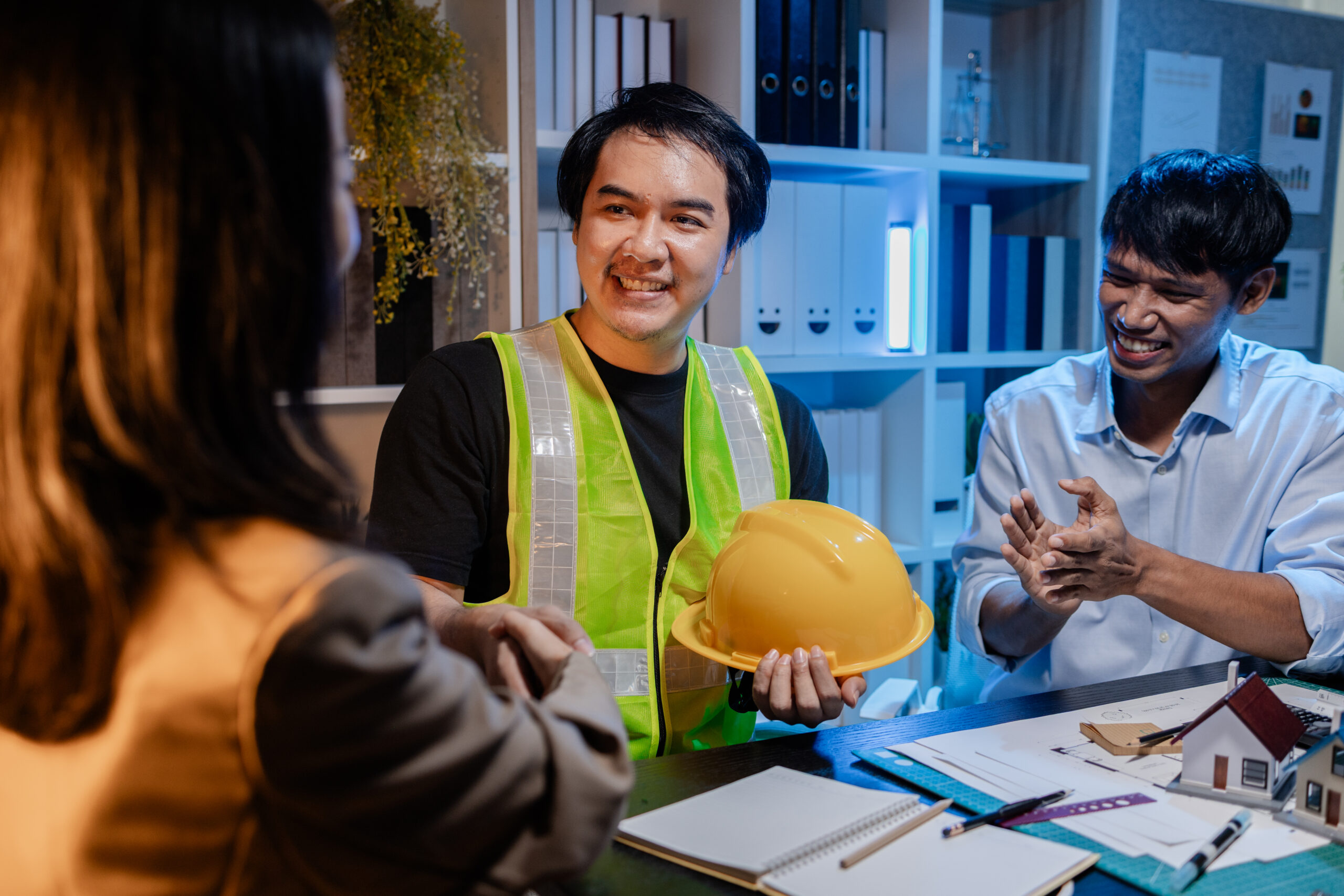 Architects and engineers work together in an office to review blueprints, exchange ideas, and refine their building plans for a contemporary construction project in an urban setting.