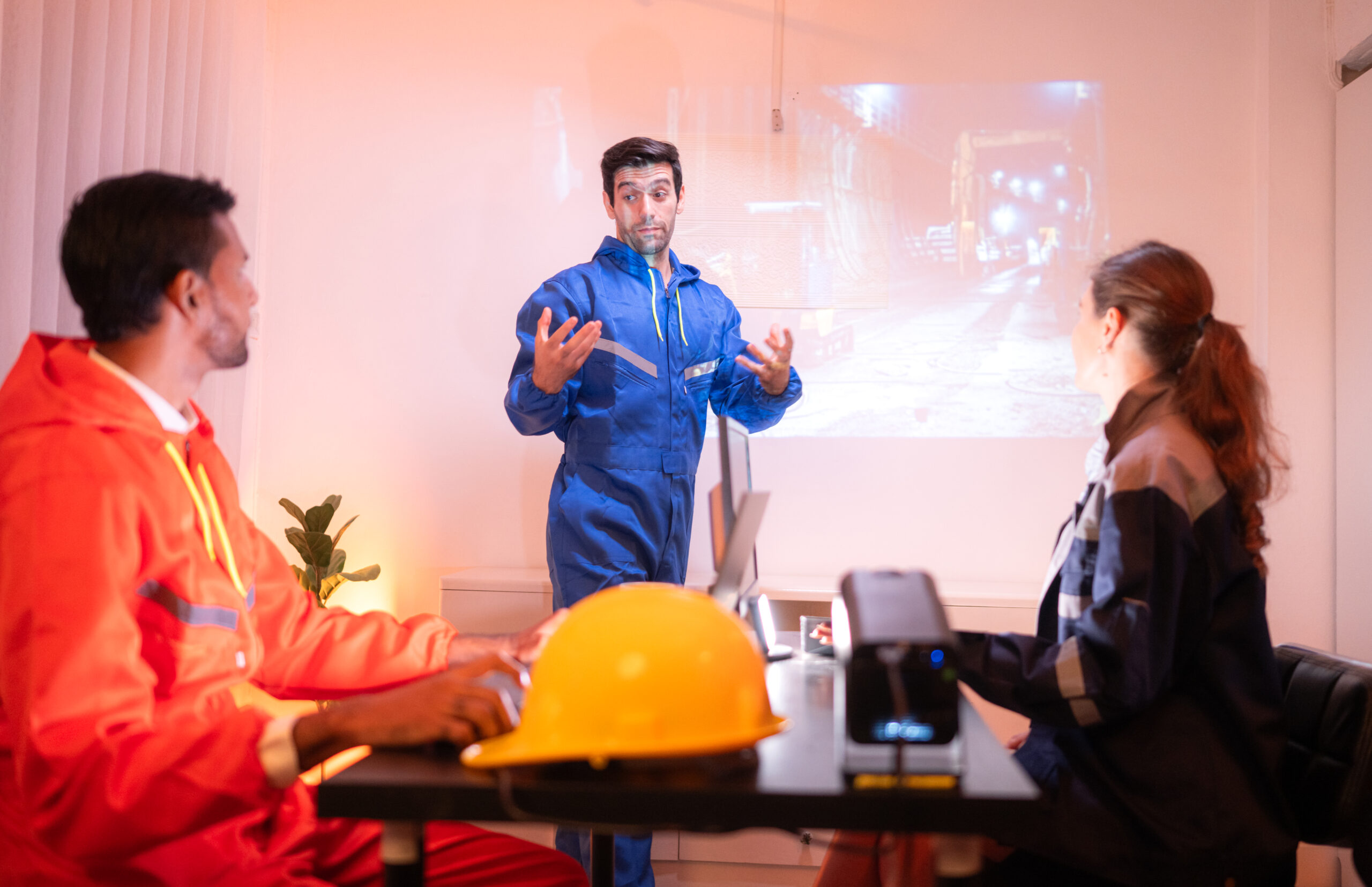 Engineers and industrial workers in safety uniforms discussing a