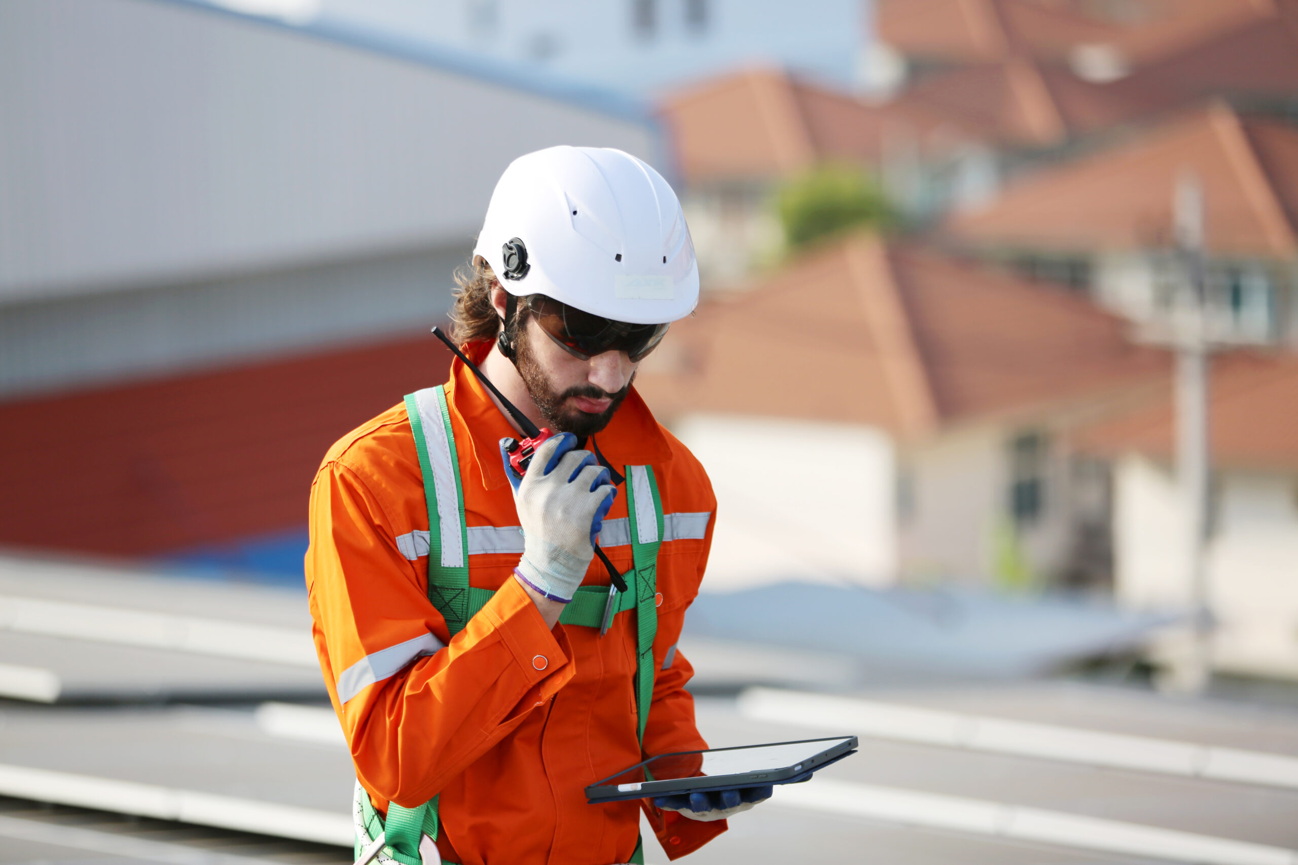 Professional worker installing solar panels on the roof of a house.